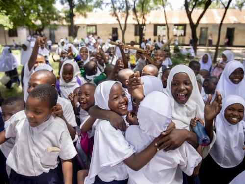 A group of children laugh and hug.