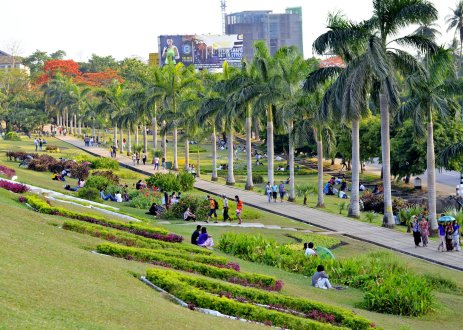 Green urban park with people walking.