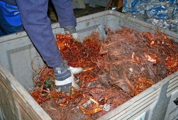 Copper wires are tangled in a recycling bin.