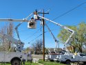 Workers repair electricity lines in a residential neighborhood.