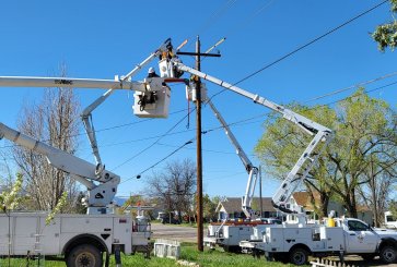 Workers repair electricity lines in a residential neighborhood.