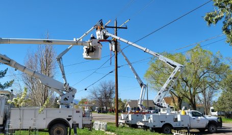 Workers repair electricity lines in a residential neighborhood.