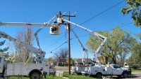 Workers repair electricity lines in a residential neighborhood.