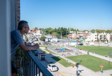 A man on his apartment balcony overlooks a new playground in his neighborhood.