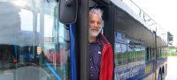 Photo of Lee Schipper, co-founder of EMBARQ, standing in a bus doorway