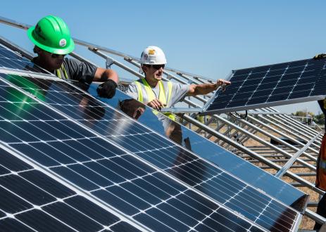 Men standing near solar panels