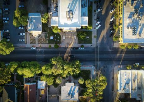 Aerial view of streets with cars and trees.