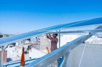 A man installing solar panels on a rooftop. 