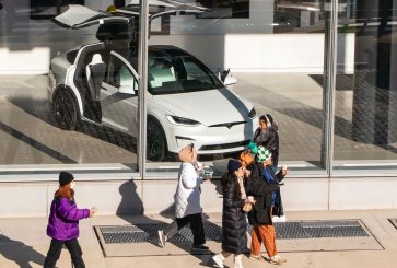 People walk by a Tesla showroom in New York City.
