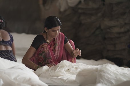 A woman sews textiles.