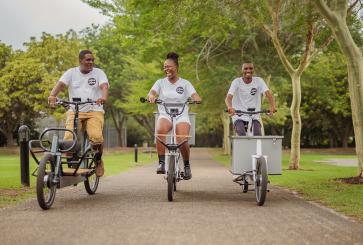 Three people riding bicycles.