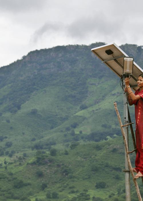Meenakshi Dewan tends to maintenance work on the solar street lighting in her village of Tinginaput, India. Huge pylons run across these hills, supplying power to the big cities – but rural areas like this are not connected to the main grid.