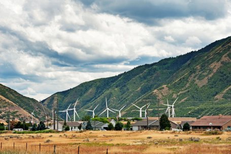 Wind turbines are located behind homes in a valley in Provo, Utah.