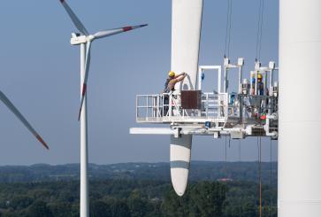 Workers repair a damaged wind turbine blade