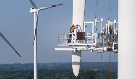 Workers repair a damaged wind turbine blade