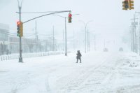 A  woman walks alone along a snow-covered street in New York City as Winter Storm Fern intensifies