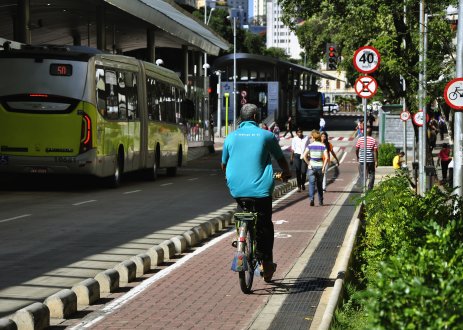 Pedestrians walking and cycling in protected lane alongside bus route.